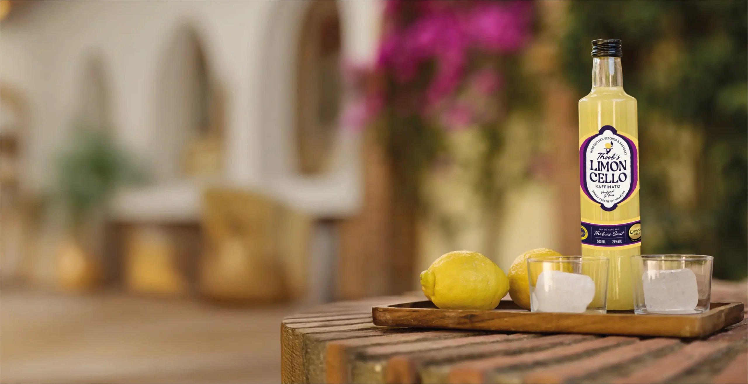 Limoncello fles met citroenen en hapjes op houten tafel, mediterrane sfeer
